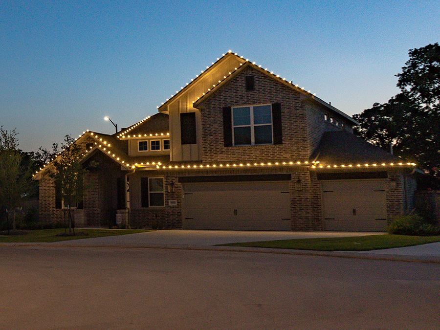 Two story house with Xmas lights over the garages and roof in Austin Texas