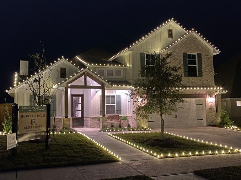 Two story house with Christmas lights that the installers hung on the roof line and around the front yard