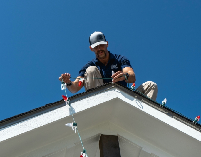 Texas Light Crew Team professionally installing white and red Christmas lights on the roof
